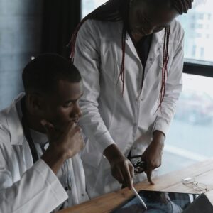 Two doctors in lab coats focus on research in a modern office setting, collaborating effectively.